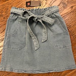 Never worn, light wash high waisted denim skirt with bow. Size Large.